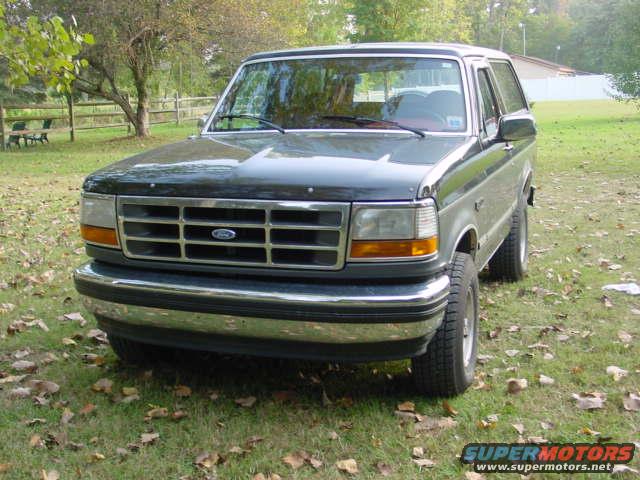 Dark green and silver 1993 Ford Bronco front 3/4 view parked on grass
