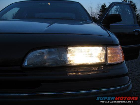 1992 Ford Crown Victoria front end with headlights on, driver's door open
