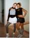 2004 Ford Taurus - Two women pose for a photo indoors, one wearing a black boa and the other with striped socks.