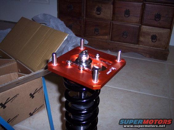 Orange adjustable strut mount with K-Sport logo and black coilover spring