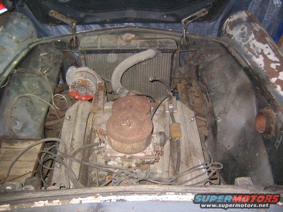 Engine bay of a 1956 Ford Thunderbird with a V8 engine, radiator, and distributor visible