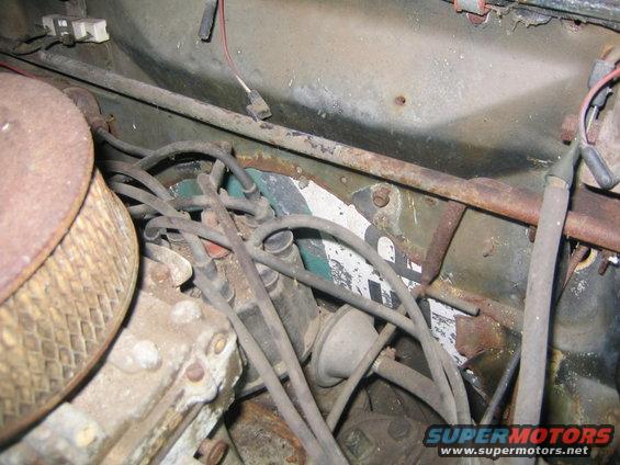 Engine bay with distributor cap, spark plug wires, and air filter housing. Some rust is visible