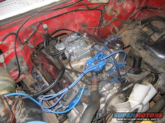 Engine bay with carburetor and blue spark plug wires