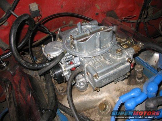 Holley carburetor with fuel lines and spark plug wires attached to engine