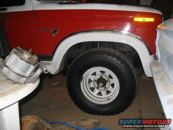 Red and white 1981 Ford Bronco front fender with horse emblem
