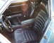 1978 Nissan 240SX - The interior of a car is visible, black leather seats and a steering wheel. Text is present on the door frame.