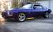 1970 Chevrolet Camaro - This 1970 Chevrolet Camaro SS features a vibrant purple paint job and custom chrome wheels, parked outdoors near a garage.