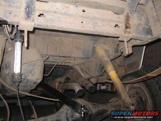 Undercarriage view showing leaf springs, shocks, differential, and dual exhaust pipes