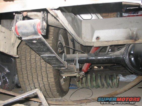 Rear leaf spring and shock absorber assembly with a tire visible