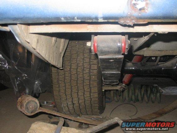Close-up of rear suspension parts, including a leaf spring and shock absorber, on a vehicle
