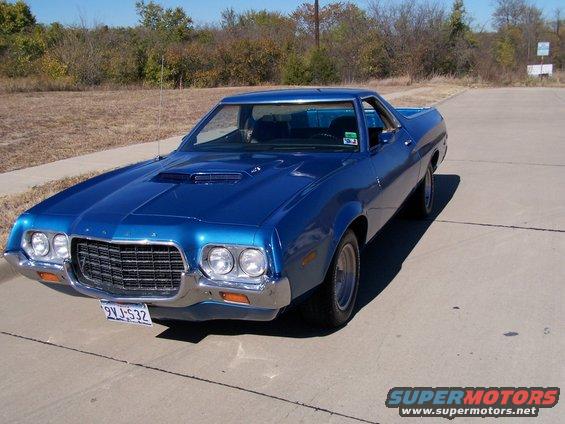 Blue 1972 Ford Ranchero parked on concrete with trees in background