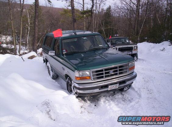 Green and silver Ford Bronco in snow, front 3/4 view, license plate CLP 33