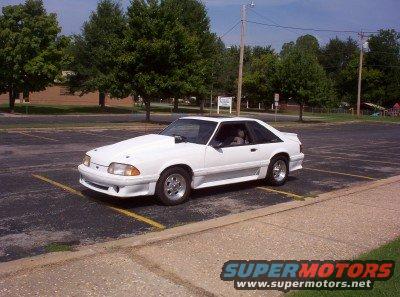White coupe with a hood scoop parked in a lot. The page claims it's a 1992 Ford Bronco, but it's not