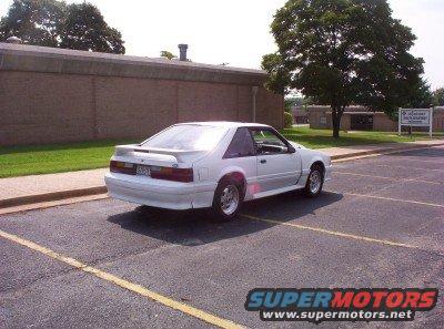 White 1992 Ford Mustang coupe parked in a lot, rear 3/4 view