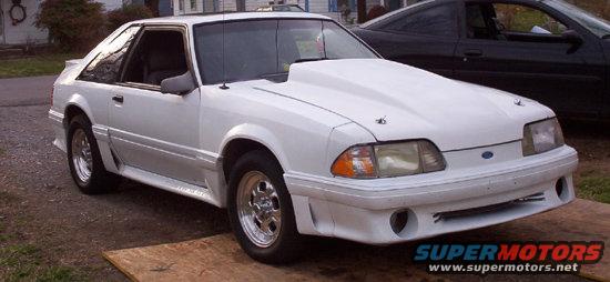 White 1992 Ford Mustang with a large hood scoop parked outside