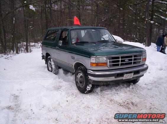 Green and silver Ford Bronco driving in snow. License plate CLP 33