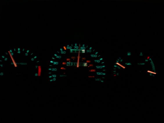 Dashboard gauges with illuminated speedometer, tachometer, fuel, and temperature gauges