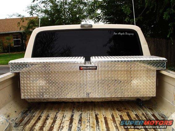 Rear view of a pickup truck bed with two diamond plate toolboxes. A sticker on the rear window reads 'San Angelo Dragway'