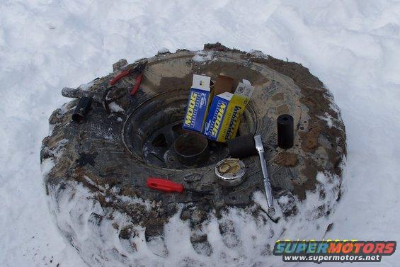 Tire with MOOG parts and tools in snow