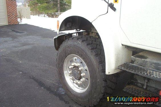 close-up of a white truck's front wheel and fender