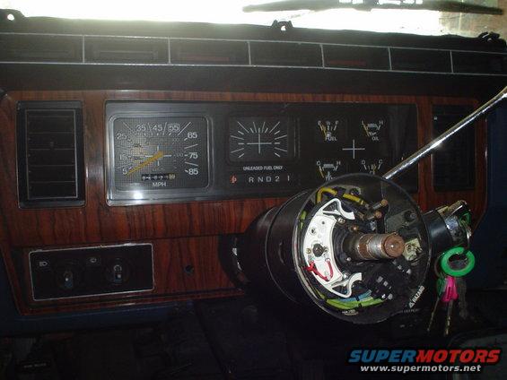 Dashboard with woodgrain trim, speedometer, fuel gauge, and exposed steering column