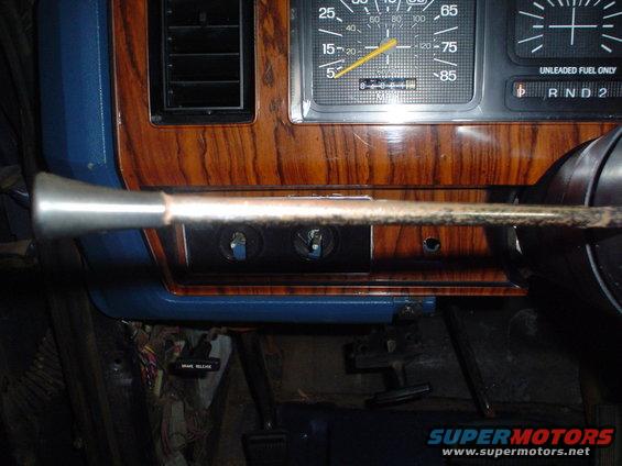 1984 Ford Bronco interior showing dashboard wood grain trim, speedometer, fuel gauge, and shifter