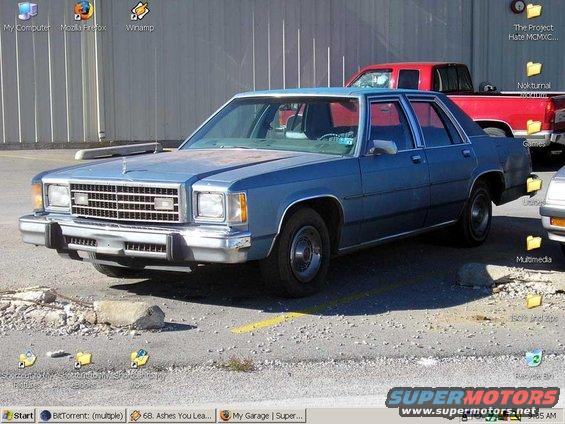 blue sedan parked outside, red truck behind it