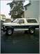 1995 Ford Bronco - Two-tone 1995 Ford Bronco parked outside a building. Supermotors.net logo visible.