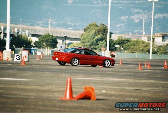 Red 1997 Ford Probe on race track, 3q-front view