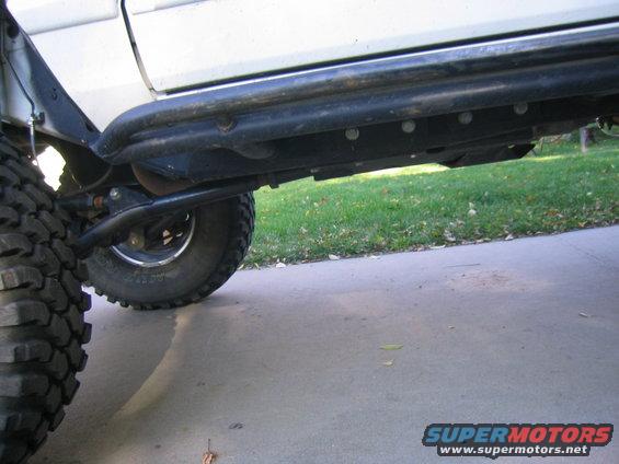 White SUV side view with off-road tires and rock sliders