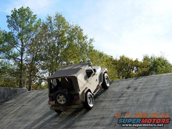 Jeep Wrangler climbing a steep incline, spare tire on back