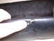 1979 Ford Bronco - Close-up of damaged black interior trim, with a finger indicating a chip.