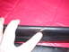 1979 Ford Bronco - Close-up of damaged black leather trim against a red background, with a finger indicating a tear.