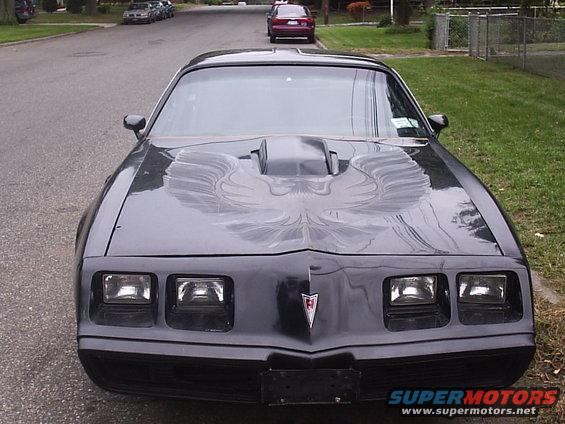 Black 1979 Pontiac Trans Am with hood decal, parked on a residential street, front view