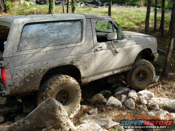 Muddy SUV climbing over rocks on a trail. Date stamp reads 12-11-2005