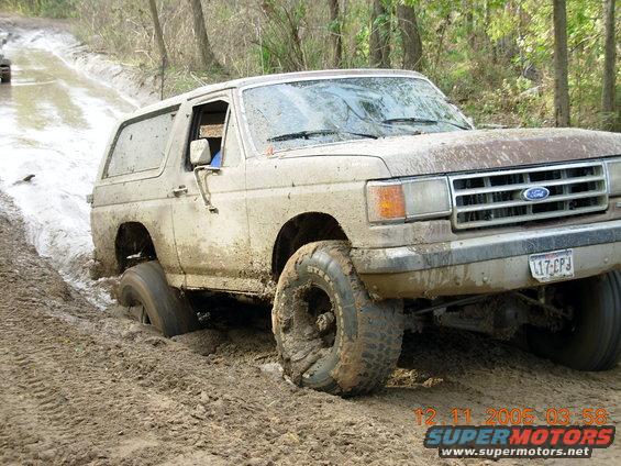 1987 Ford Bronco stuck in mud, front 3/4 view