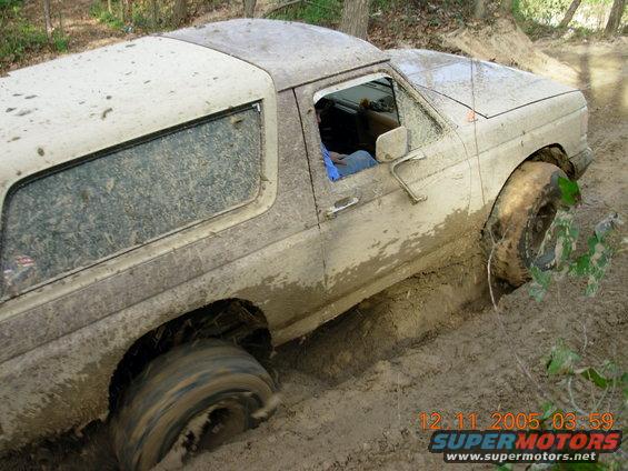 1987 Ford Bronco stuck in mud on an off-road trail