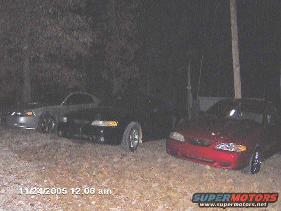 Red 1996 Ford Mustang front view, parked with two other Mustangs