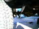 1987 Ford Bronco II - Underneath view of a vehicle's suspension components and tire, with tools nearby.