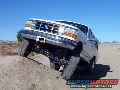 White 1995 Ford Bronco with lifted suspension on a dirt incline