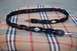 1990 Ford Bronco - Two braided leather straps with decorative diamond accents and metal clasps are displayed on a plaid fabric surface.