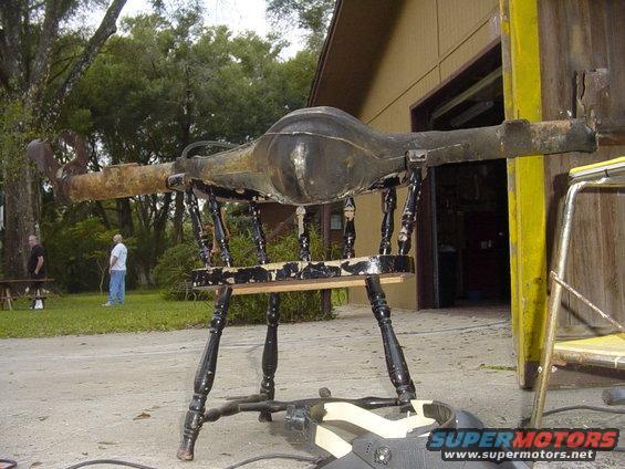 Rear axle assembly on a chair, Supermotors.net logo visible