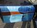 1993 Ford Bronco - Interior view of a car door panel blue vinyl and woodgrain trim.