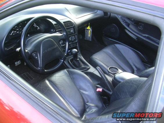 Red 1997 Ford Probe interior with black leather seats, dashboard, steering wheel, and gear shifter