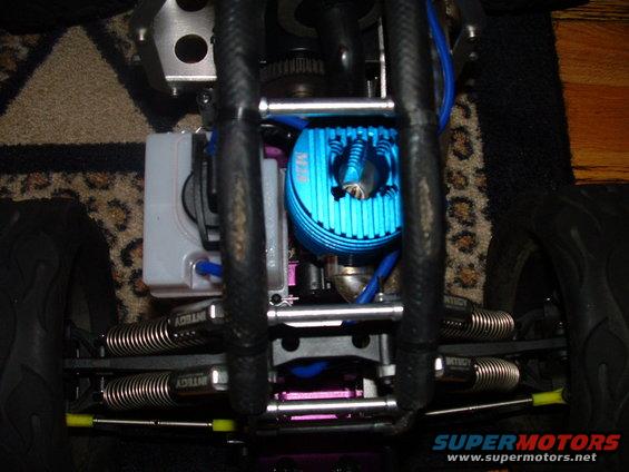 Remote control car engine with blue heatsink, silver springs, and black chassis, viewed from above