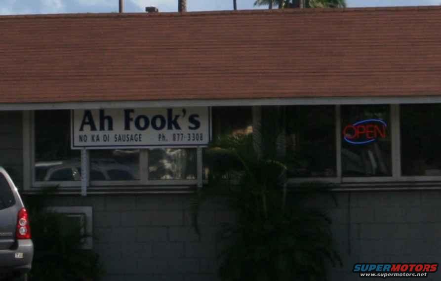 Building exterior with 'Ah Fook's NO KA OI SAUSAGE' sign and an 'OPEN' neon sign