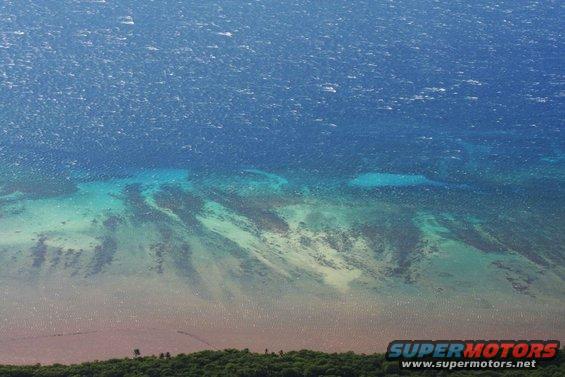 Aerial view of ocean and coastline with Supermotors logo