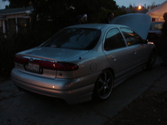 1995 Ford Taurus sedan, silver, hood open, aftermarket wheels