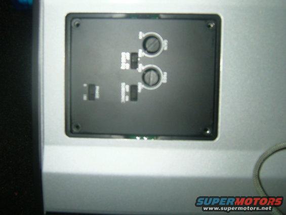 Audio amplifier control panel with two knobs and several switches, one labeled SUBSONIC