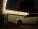 1993 Ford Probe - A white sedan is parked in front of a garage at night, adorned with festive lights.